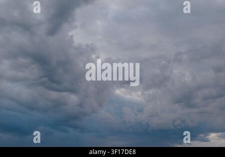 Dramatic dark storm clouds filling the sky early in the morning in the French countryside. Stock Photo