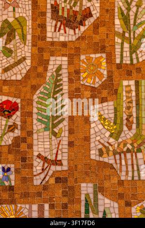 Malmo, Sweden - August 13, 2025. A detailed mosaic tile mural with botanical patterns of leaves and flowers in warm earthy tones decorates a historic Stock Photo