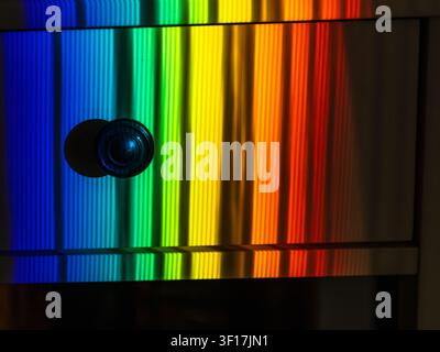 Abstract rainbow light spectrum reflected on glossy metallic surface, creating colorful geometric background with vivid gradients Stock Photo
