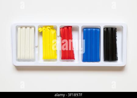 A set of colored play dough in plastic packaging on a white background. Materials for children's creativity, modeling, and art activities Stock Photo