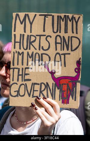 Handwritten Sign October A demonstrator holds a handwritten sign reading