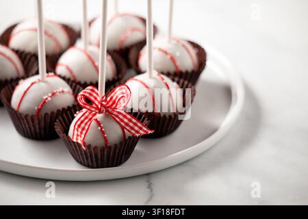 A plate of decorated cake balls with sticks, ready for sharing. Stock Photo