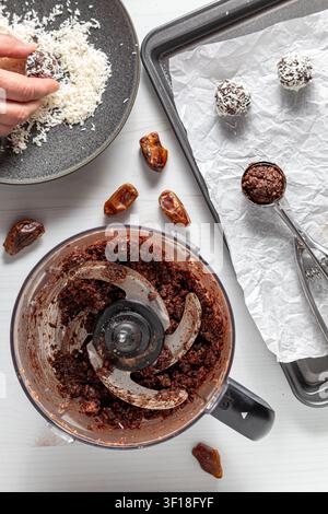 Flat-lay overhead view of assembling coconut dusted energy balls. Stock Photo