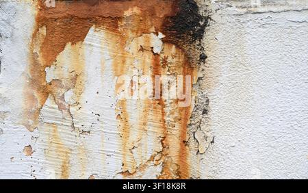 Rust stains and peeling paint on an old weathered concrete wall texture. Stock Photo