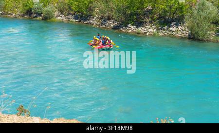 Antalya, Turkey - June 03, 2026: A group of individuals wearing yellow helmets navigates a raft on the Koprucay River, with greenery and rocks visible Stock Photo