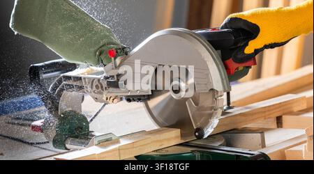 Cutting wood using table saw at construction site Stock Photo