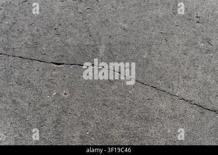 Cracked basalt stone texture background, top view of grey volcanic lava paving slabs with cracks, full frame natural stone pavement pattern for archit Stock Photo