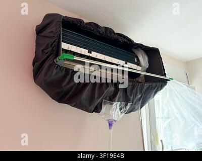 Close view of wall mounted split air conditioner indoor unit covered for cleaning service Stock Photo