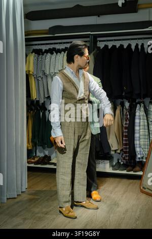 Professional tailor measuring gentleman in bespoke suit at high-end atelier shop, artisan tailoring craftsmanship and sartorial fitting process Stock Photo