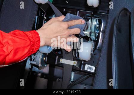 Technical engineer repairing and measuring the electronic motherboard of an electric massage chair with professional tools, hardware repair service. Stock Photo