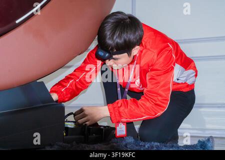 Technical engineer repairing and measuring the electronic motherboard of an electric massage chair with professional tools, hardware repair service. Stock Photo