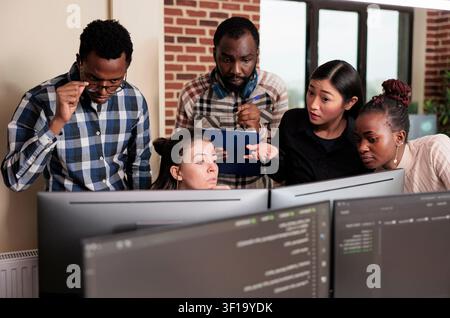 Tech engineers program cybersecurity application together with code, databases and network security work focused on data protection, firewalls and software development Stock Photo
