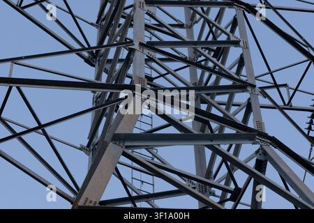 Steel tower rises against clear blue sky. Metal framework shows complex engineering design Stock Photo