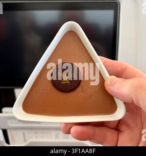 Chocolate mousse is served in a triangular dish on an airplane. Stock Photo