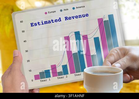 Hand holding digital tablet showing estimated revenue growth on screen while drinking a cup of coffee. Stock Photo