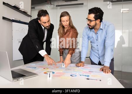 Business team analyzing data charts discussing strategy in corporate office Stock Photo