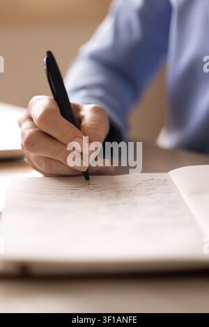 Closeup view female hand writing in notebook Stock Photo