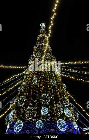 Decorated Christmas tree with multi-colored lights at night Stock Photo