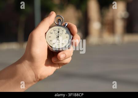 Hand holding a vintage mechanical stopwatch, time measurement and precision timing for sports or industry Stock Photo