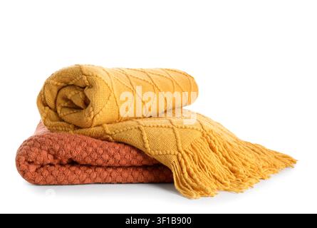 Stacked orange and yellow knitted blankets with fringe, cozy home decor and comfort concept, isolated on a white background Stock Photo