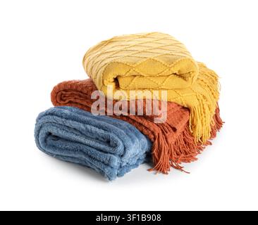 Stack of three folded cozy blankets in yellow, orange, and blue colors, isolated on a white background Stock Photo
