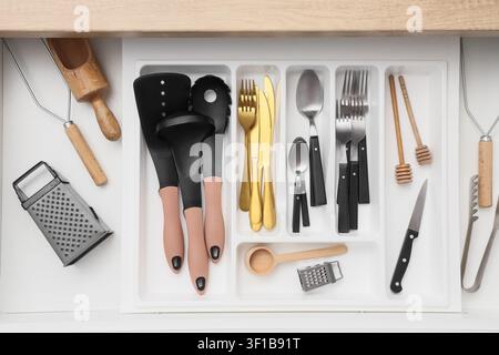Organized kitchen drawer with various cooking utensils, cutlery, and kitchenware for home cooking and meal preparation Stock Photo