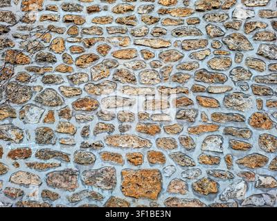 This natural stone wall features an array of shapes and colors, providing a rustic look that adds character to any outdoor space. The unique textures Stock Photo
