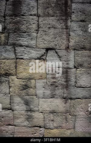 A close-up view fills the frame with a wall constructed from roughly hewn, rectangular sandstone blocks, varying in shades of grey, beige, and light b Stock Photo
