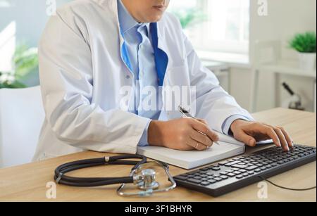Close-Up Of Doctor Writing Prescription In Clinic Stock Photo