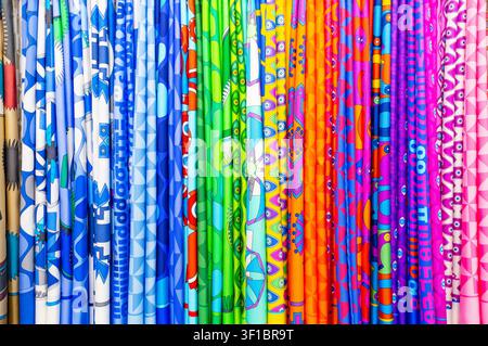 Abstract background of hanging colorful silk fabrics with vibrant rainbow patterns and geometric prints Stock Photo