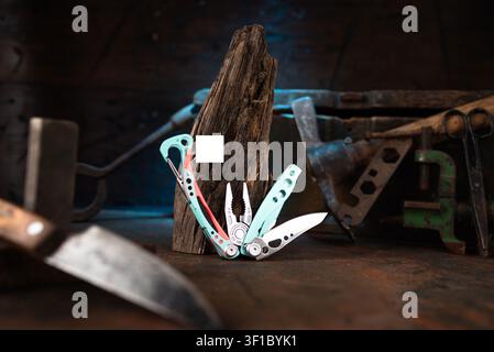 Modern multitool with vintage tools on a dark wood background. Stock Photo