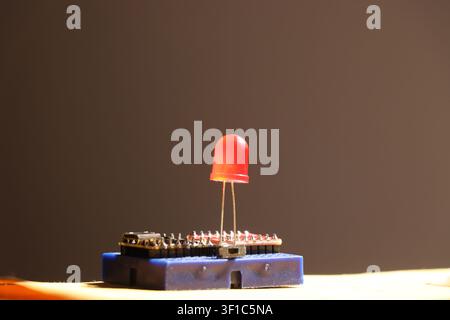 Red led connected on blue circuit board with microcontroller for electronics project Stock Photo