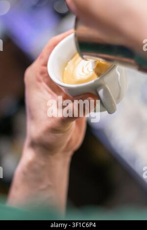 Close-up of barista preparing cappuccino with latte art Stock Photo