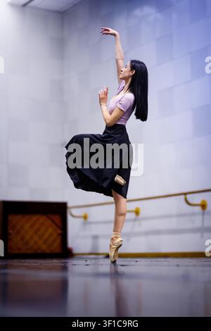 Ballet dancer practices in a studio during a rehearsal for an upcoming performance Stock Photo