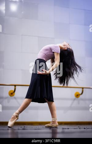 Dancer performs an expressive movement in a dance studio during a rehearsal session Stock Photo