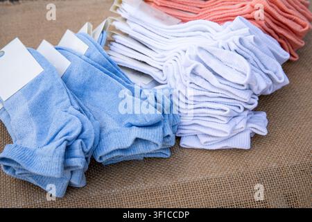 Stacks of colorful cotton ankle socks arranged on natural burlap background Stock Photo