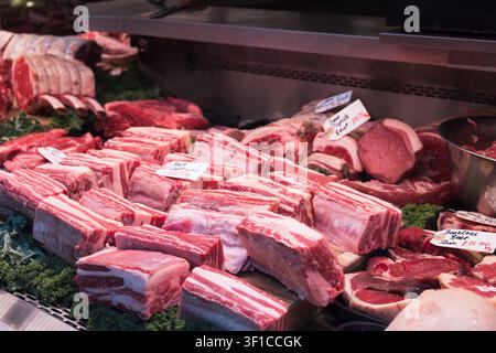 Raw beef ribs and steaks on display at a butcher shop Stock Photo