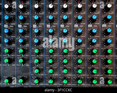 Close up of professional audio mixing console with colorful knobs and sliders in modern event venue, sound engineering equipment for conference or liv Stock Photo