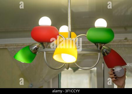 man changes light bulb in lamp, focusing on energy saving and longevity. Lamp reflects technology shift and personal responsibility. concept of energy Stock Photo