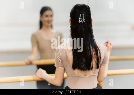 Ballet dancer practices at a studio in front of a mirror during afternoon hours to improve skills and focus on technique Stock Photo