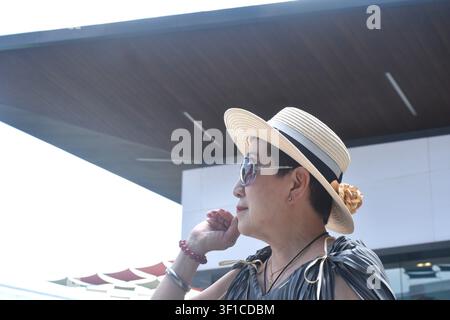 elder woman strong and healthy wearing hat in community mall garden Stock Photo
