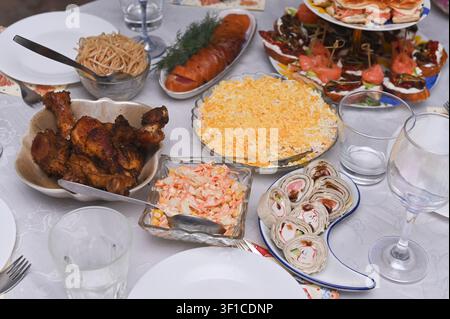 Catering service provides assorted gourmet appetizers for festive event. Delicious snacks like meat sliders and fish bruschetta are arranged on table. Stock Photo
