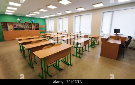 classroom with rows of desks and chairs in bright school interior with large windows. classroom empty without students, education environment, clean s Stock Photo