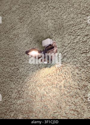 Germany 2026 secure wall-mounted security light illuminates textured concrete exterior wall, providing a functional and secure setting for home improv Stock Photo
