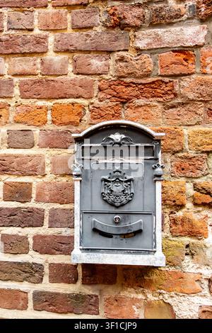 Decorative vintage metal mailbox mounted on historic brick wall in Stade, Germany, architectural detail of old town Stock Photo