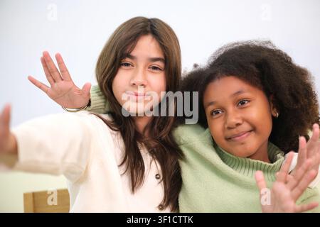 Two girls waved and smiled in the classroom. Stock Photo