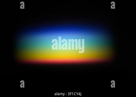 Light refracting through prism creating colorful rainbow spectrum on black background Stock Photo