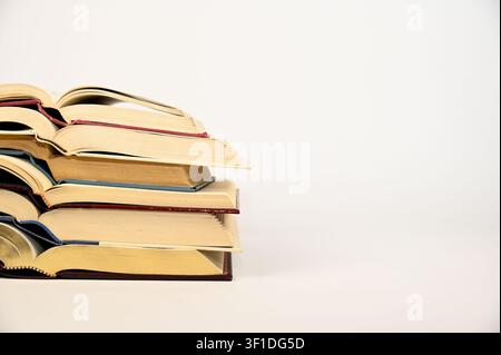 Hardback books opened to the center and stacked neatly on top of one another Stock Photo