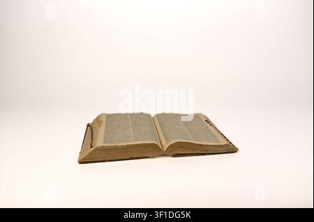 1920’s hardback dictionary open with aged pages showing on white background Stock Photo