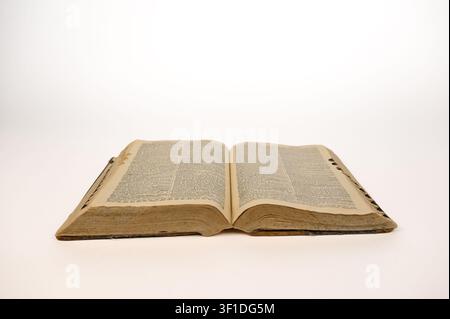 1920’s hardback dictionary open with aged pages showing on white background Stock Photo
